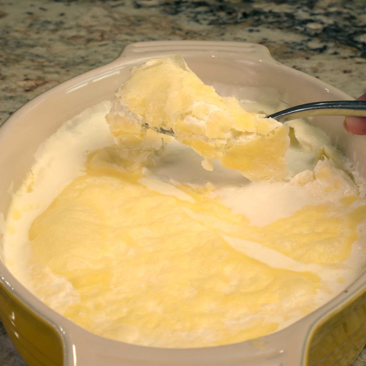 spooning clotted cream out of a dish