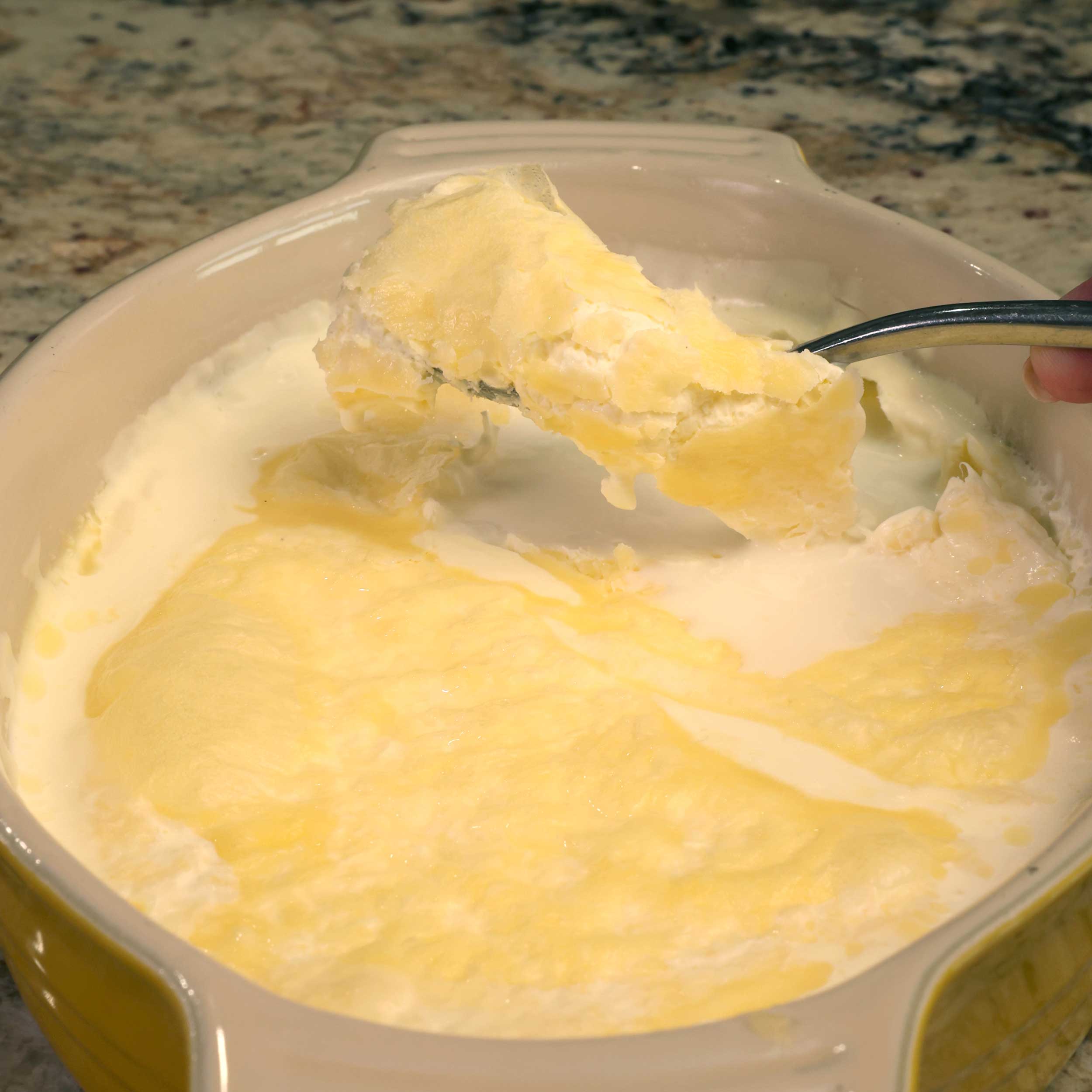 spooning clotted cream out of a dish.