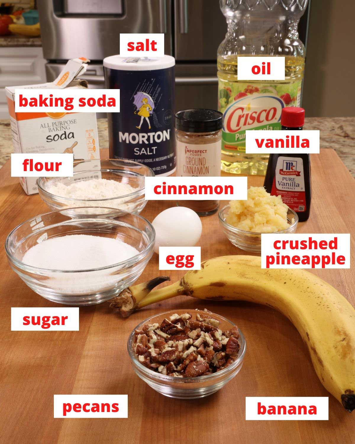 ingredients to make a hummingbird cake on a wooden cutting board.