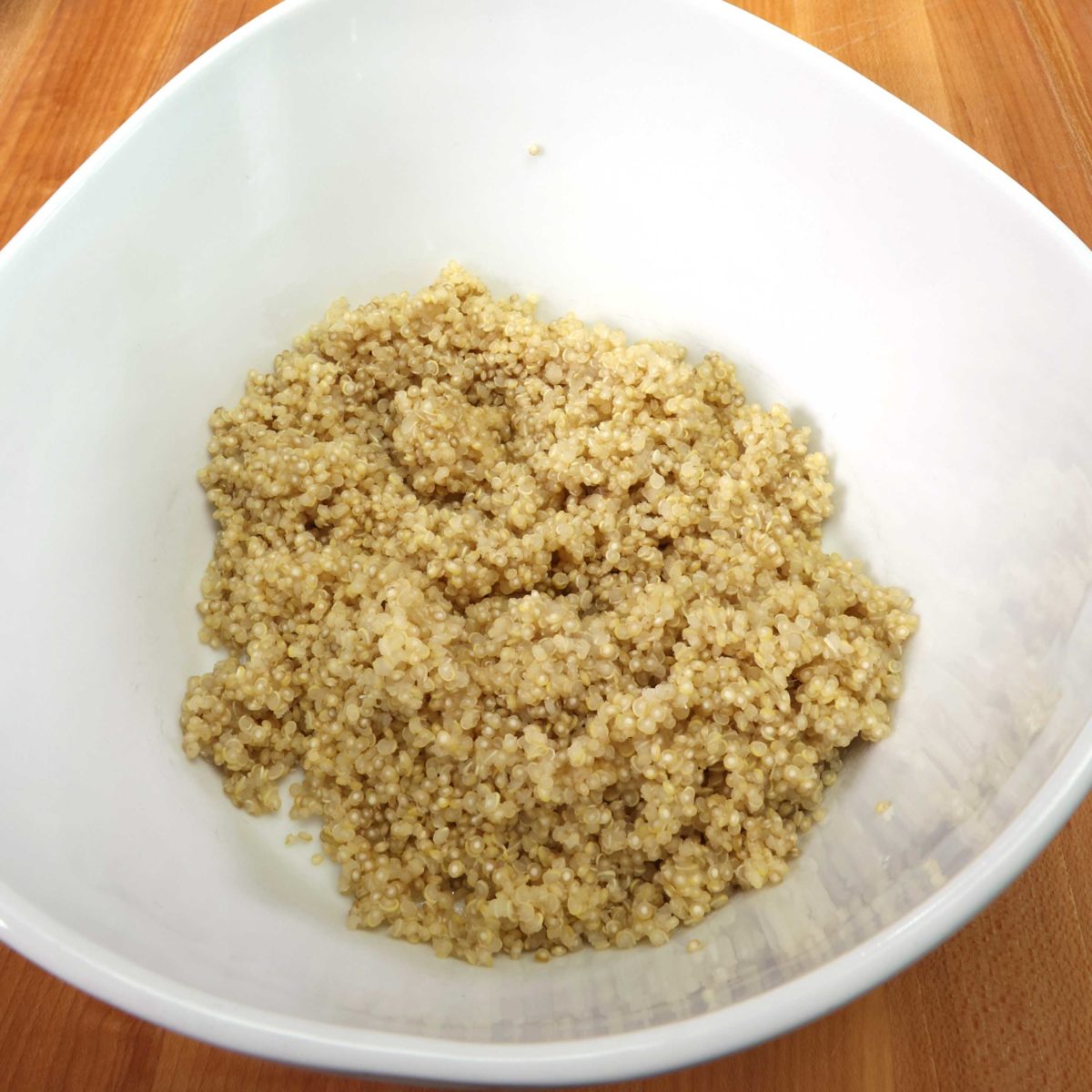 cooked quinoa in a white bowl.