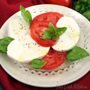 a small Caprese salad on a white plate.