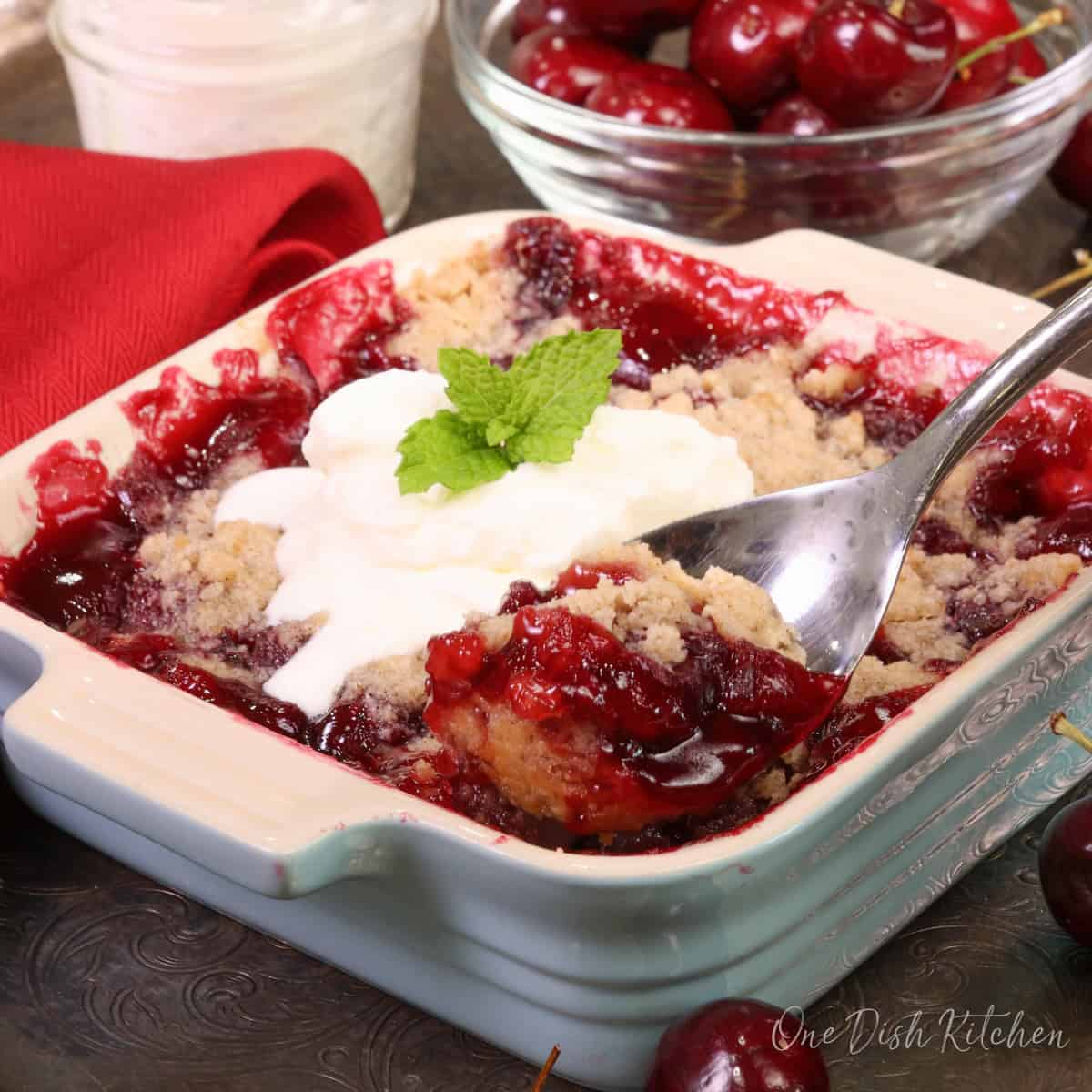 a single serving cherry pie in a square dish.