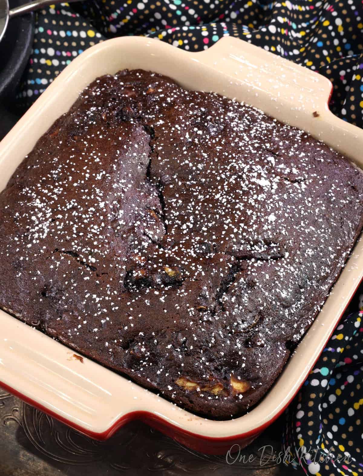a small loaf of chocolate zucchini bread in a square baking dish.