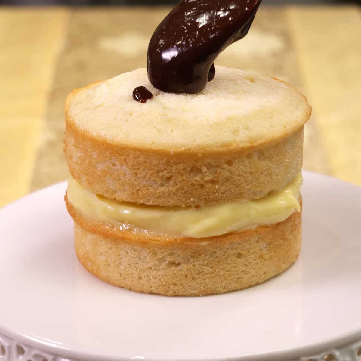 drizzling ganache over a boston cream pie.