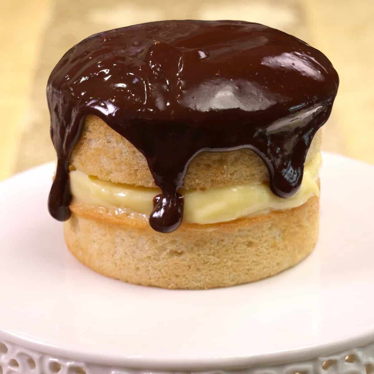 a mini boston cream pie on a cake plate.