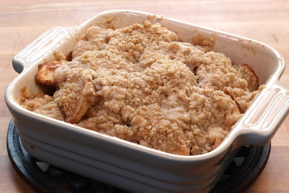a small dutch apple pie in a square blue baking dish.