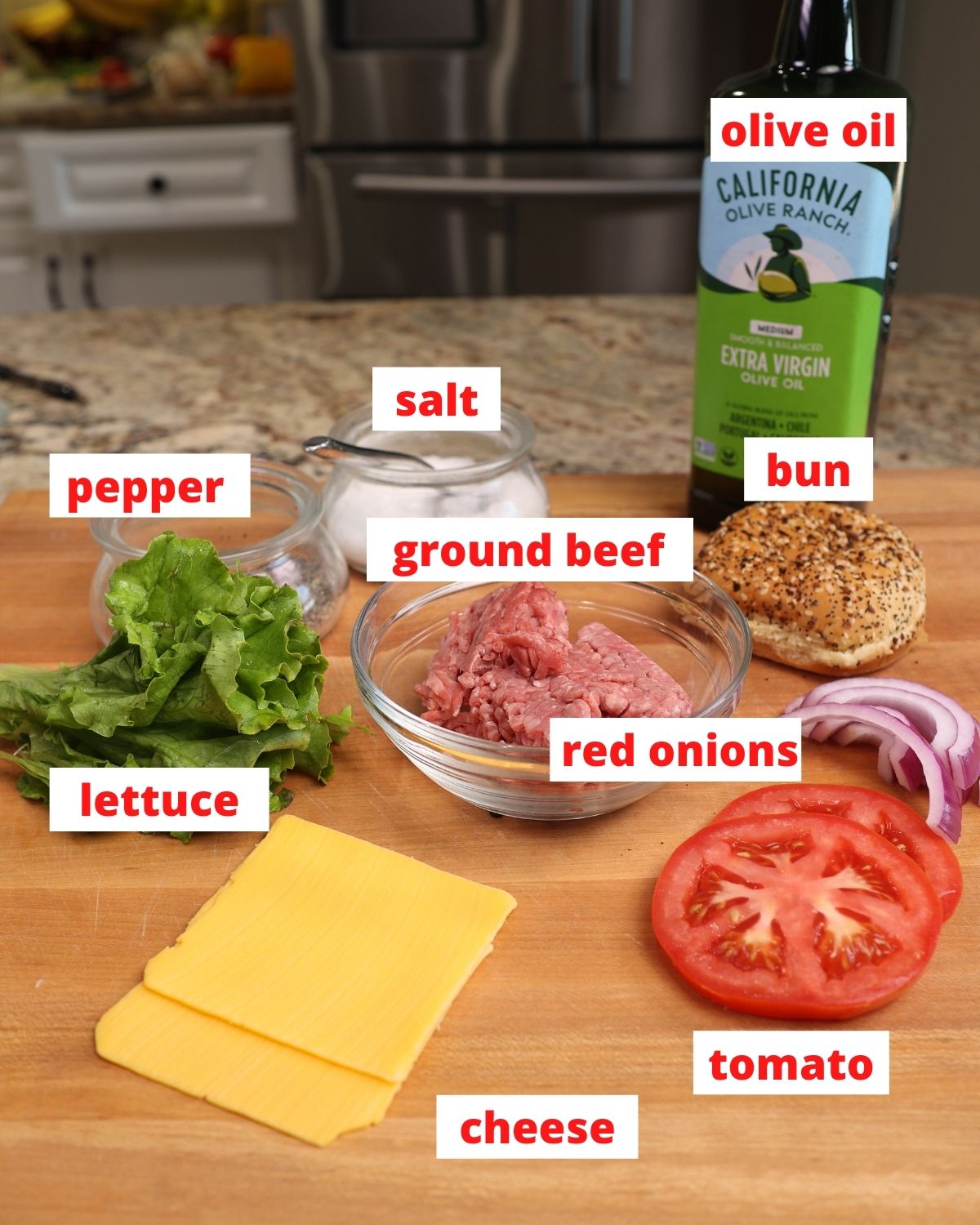 ingredients to make a hamburger on a cutting board; ground beef, cheese, lettuce, tomatoes, and onions.