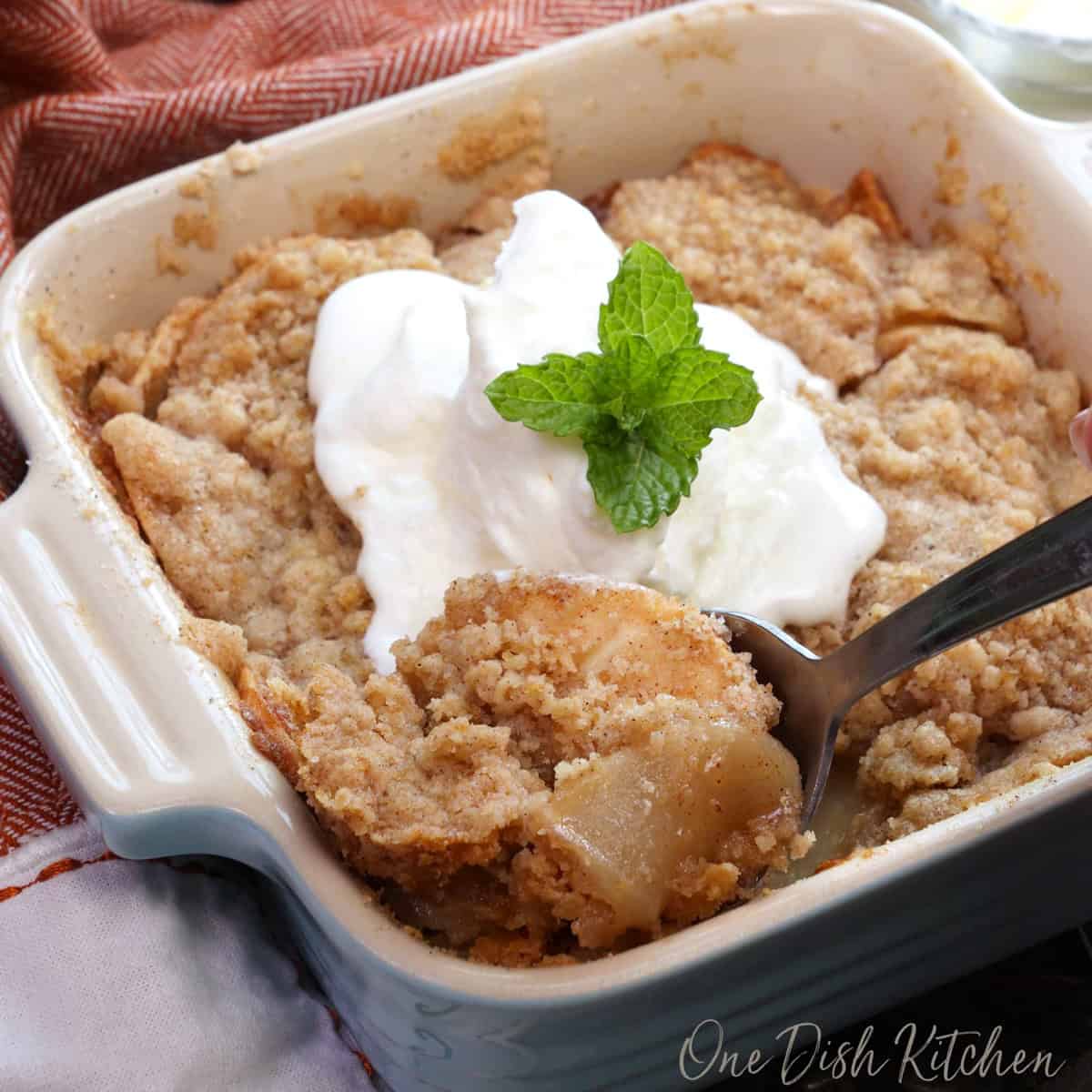a small dutch apple pie in a square blue baking dish.
