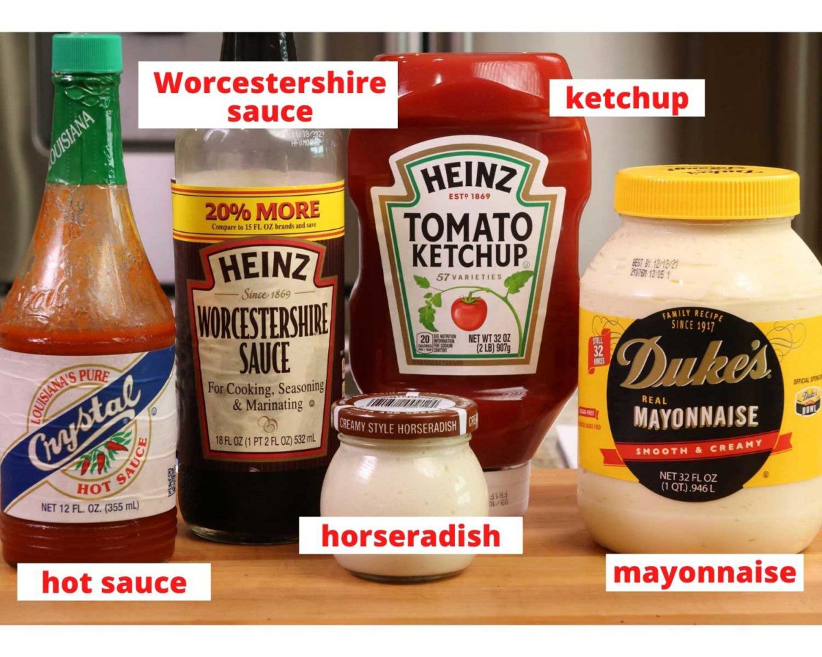 russian dressing ingredients on a wooden cutting board: ketchup, mayonnaise, hot sauce, horseradish, and worcestershire sauce