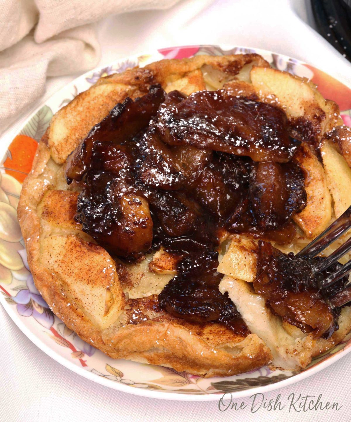 an apple dutch baby topped with fried apples.