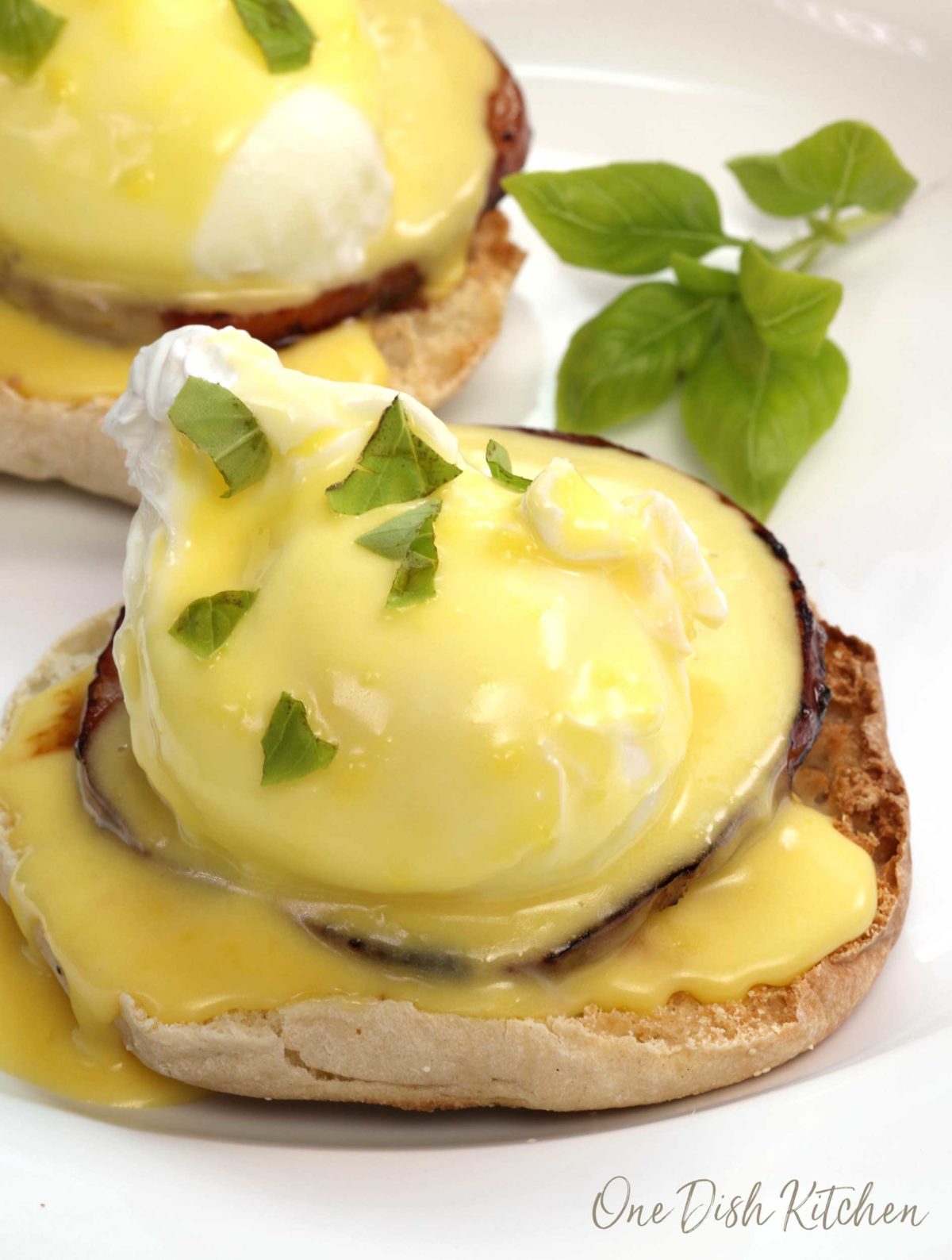 a close up of an eggs benedict smothered in hollandaise sauce.