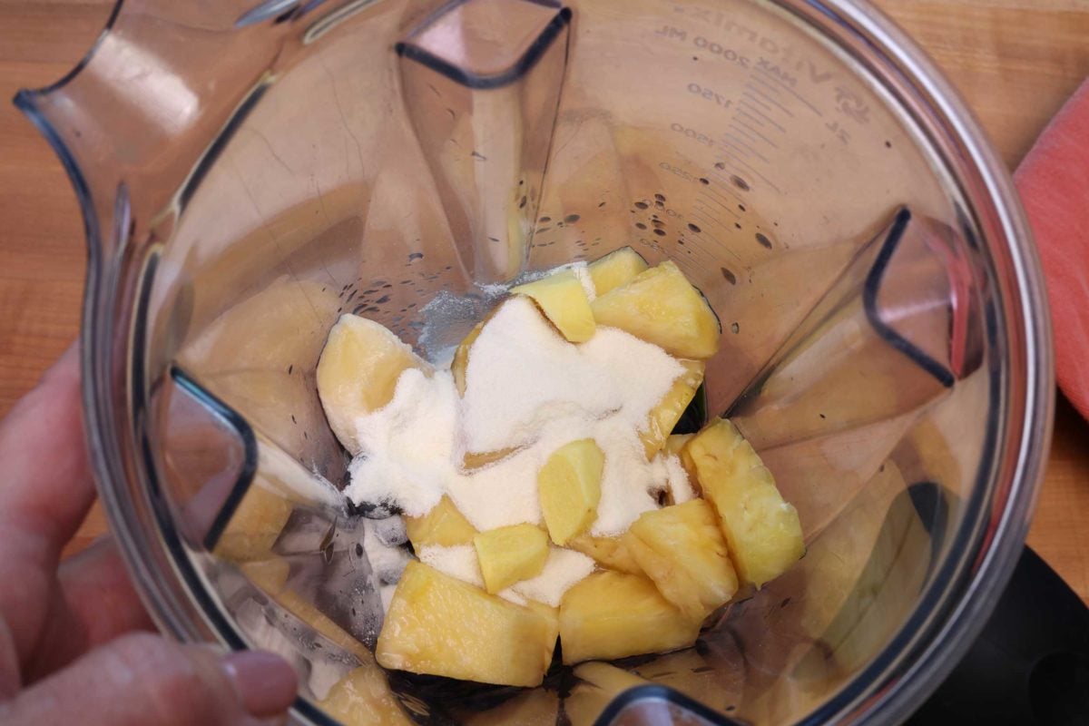 spinach, pineapples, and protein powder in a blender.