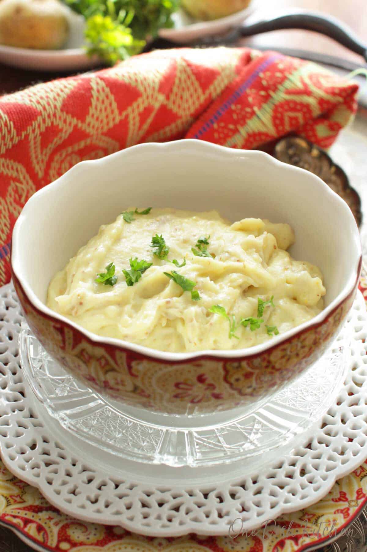 a bowl of mashed potatoes on a silver tray.