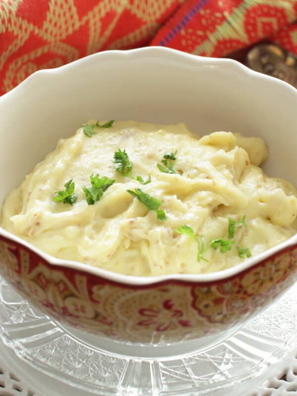 a bowl of mashed potatoes on a silver tray.