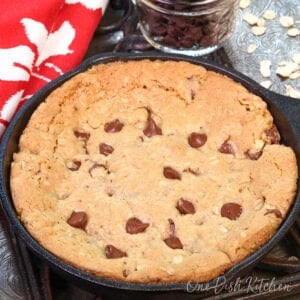 a mini oatmeal chocolate chip skillet cookie in a small cast iron skillet.