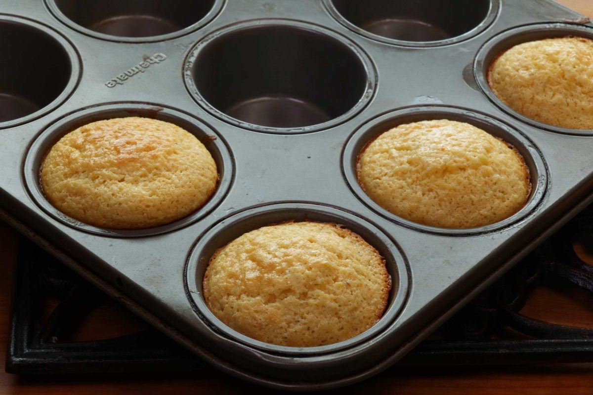 four corn muffins in a muffin pan.