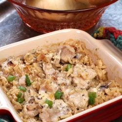 a mini chicken and rice casserole topped with chopped green peppers in a square red baking dish