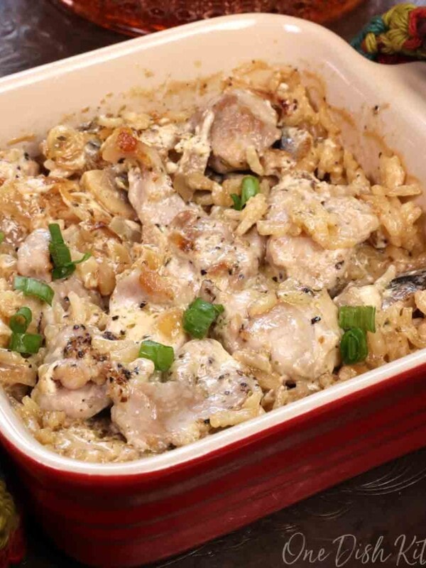 a mini chicken and rice casserole topped with chopped green peppers in a square red baking dish