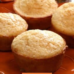 four corn muffins on an orange plate.
