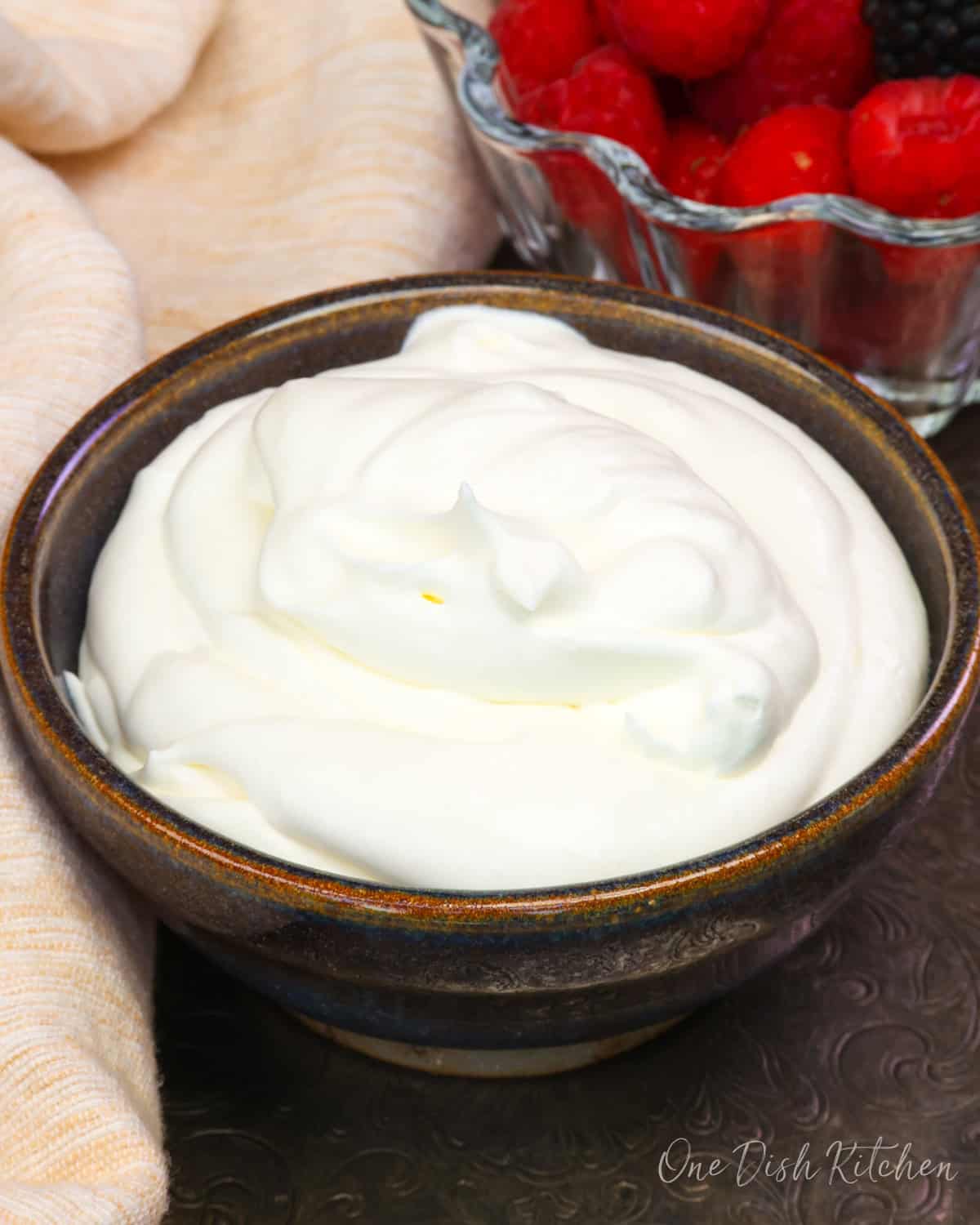 a small batch of homemade whipped cream in a purple bowl.