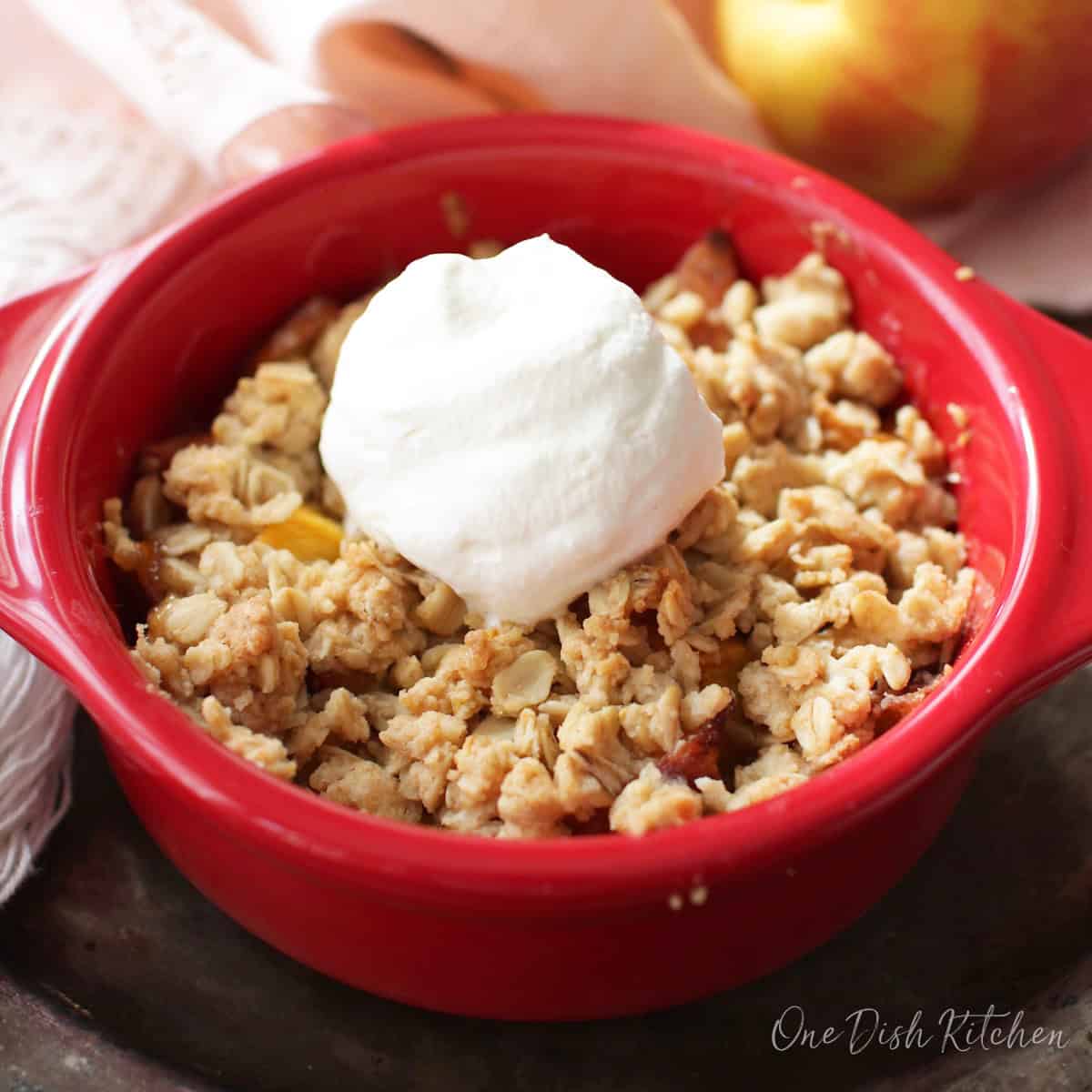 a small peach crisp topped with homemade whipped cream.