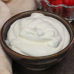 a small batch of homemade whipped cream in a purple bowl.