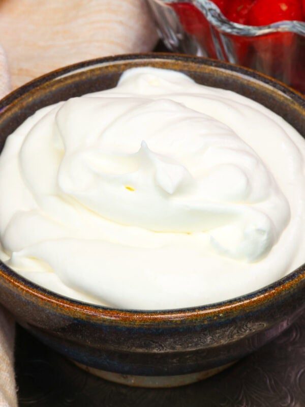 a small batch of homemade whipped cream in a purple bowl.