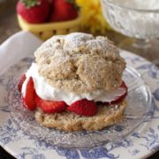 whipped cream and strawberries between two biscuits on a plate