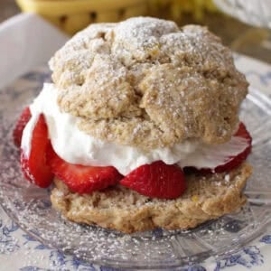 strawberry shortcake with whipped cream on a white plate.