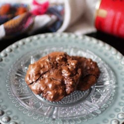chocolate cookies on a green plate next to a pink napkin
