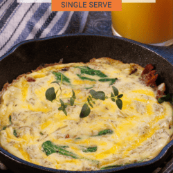 Frittata with bacon and spinach shown in a small cast iron pan.