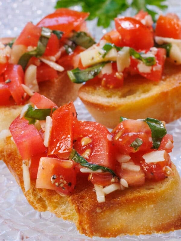 a single serving of bruschetta topped with fresh tomatoes, garlic and basil.