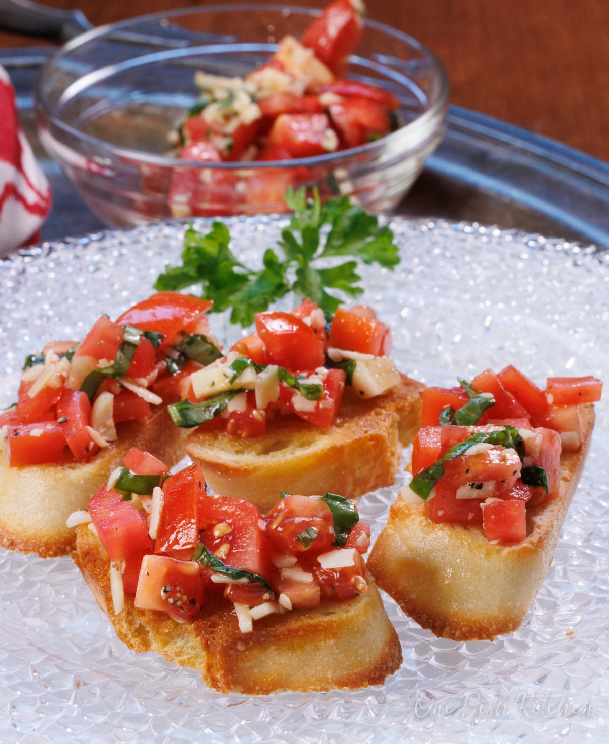 four pieces of bruschetta on a clear plate.