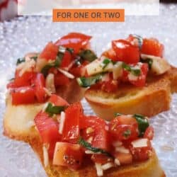 three slices of toasted french bread topped with fresh tomatoes, garlic, and basil.