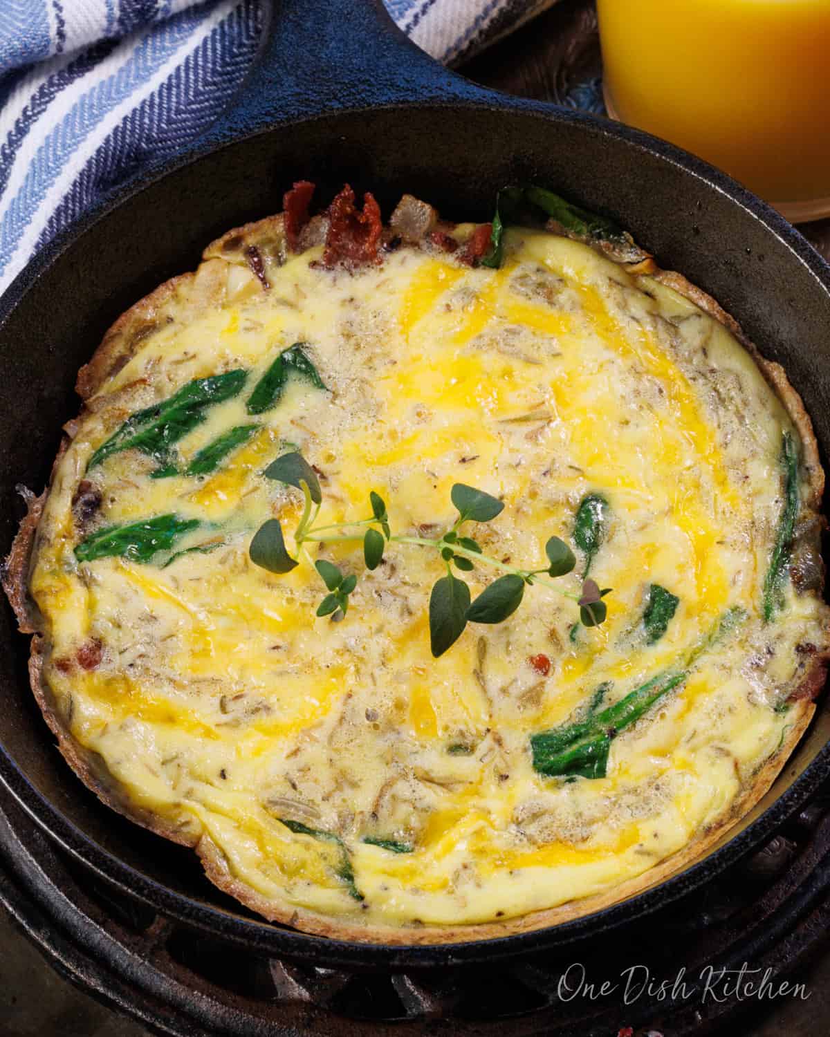 a mini spinach and bacon frittata in a small cast iron skillet.