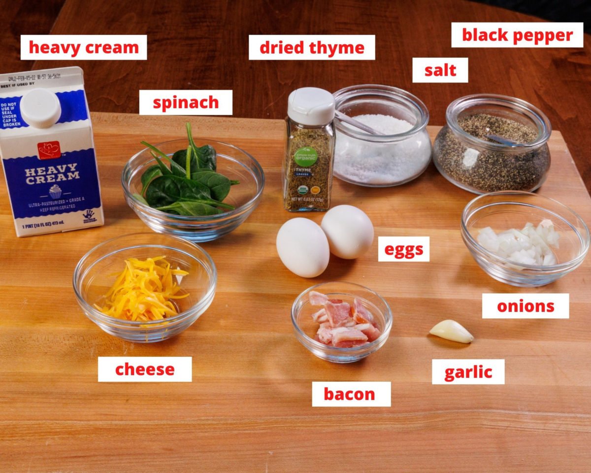 ingredients for a spinach and bacon frittata on a wooden cutting board.