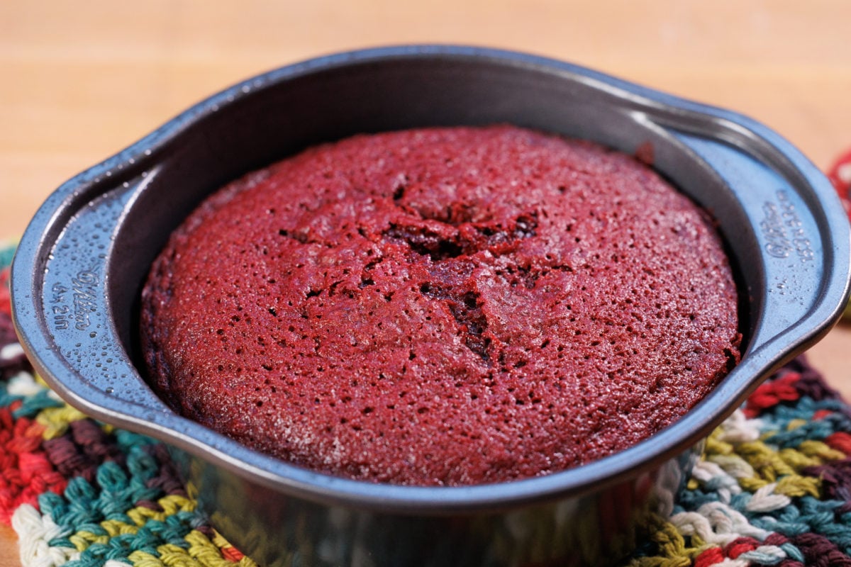an unfrosted red velvet cake in a cake pan.