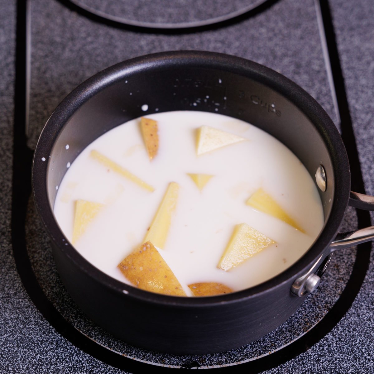 potatoes in milk inside a small saucepan.