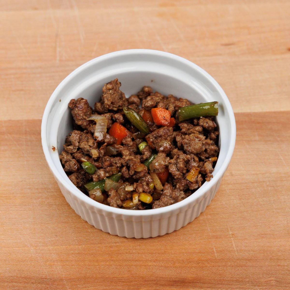 ground lamb and vegetables in a small ramekin.