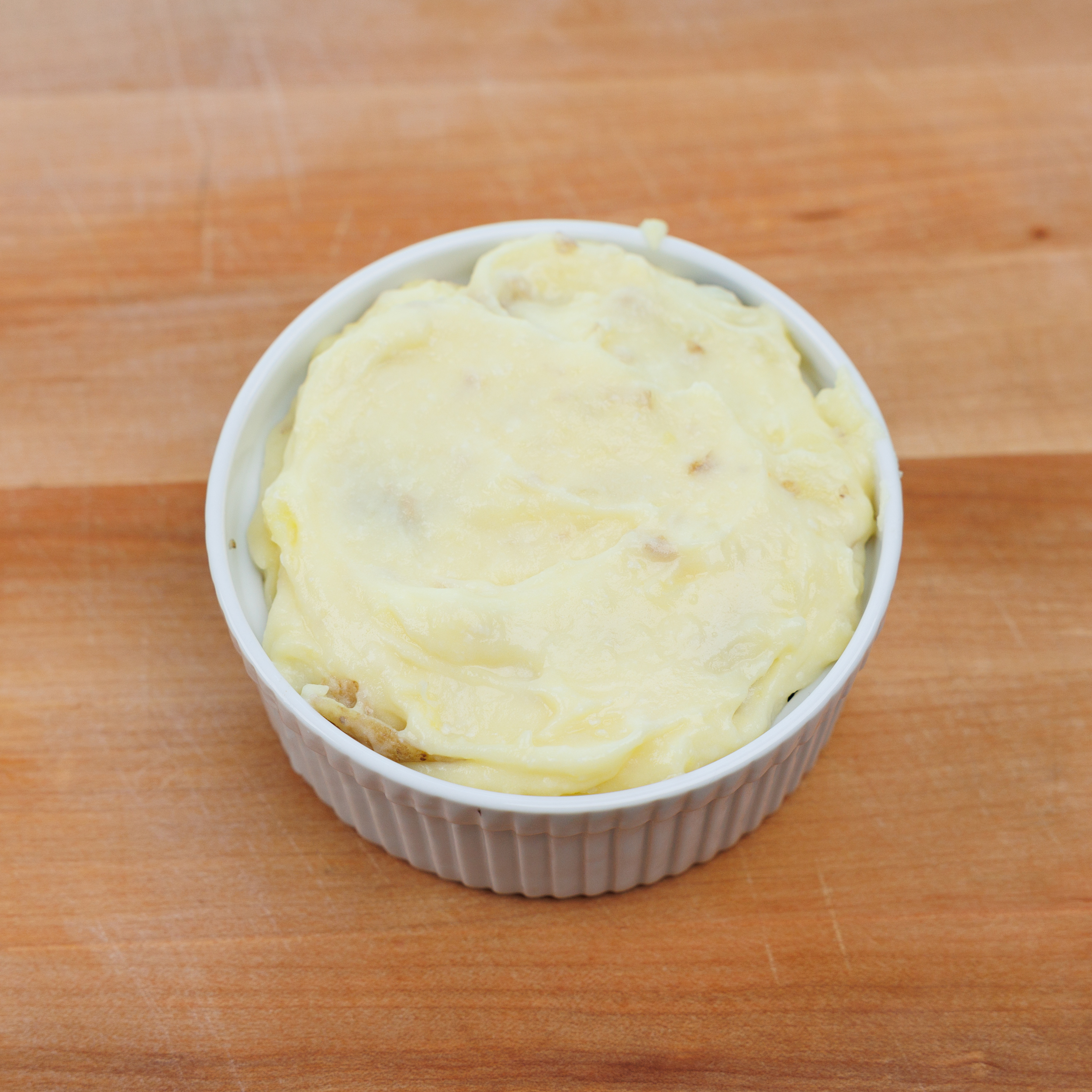 mashed potatoes on top of a small shepherds pie