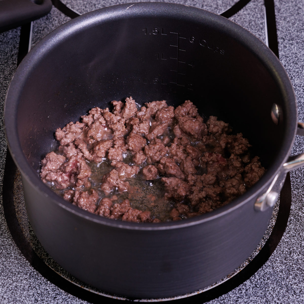 ground beef in a small black pot.
