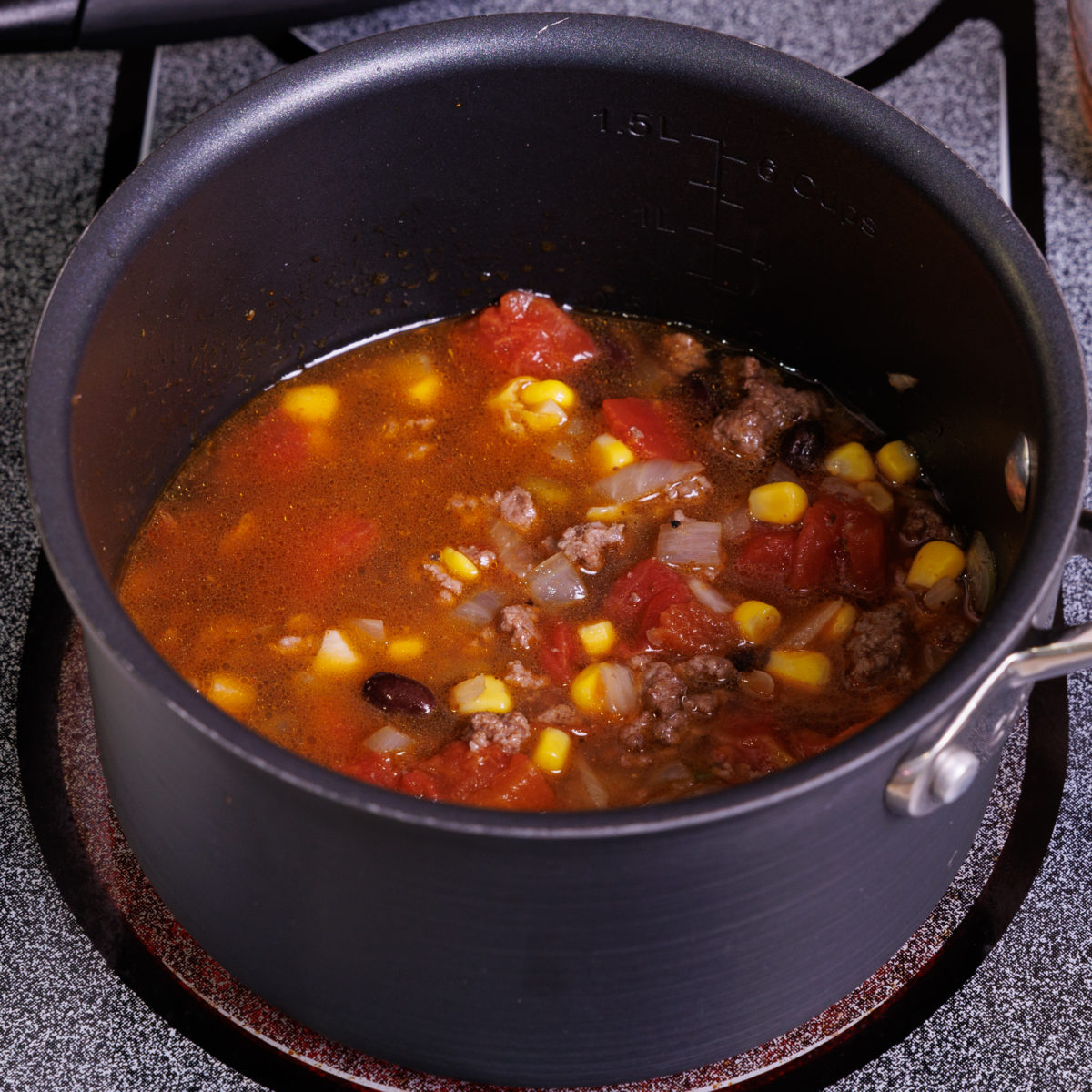 a small pot of simmering taco soup on a stove.
