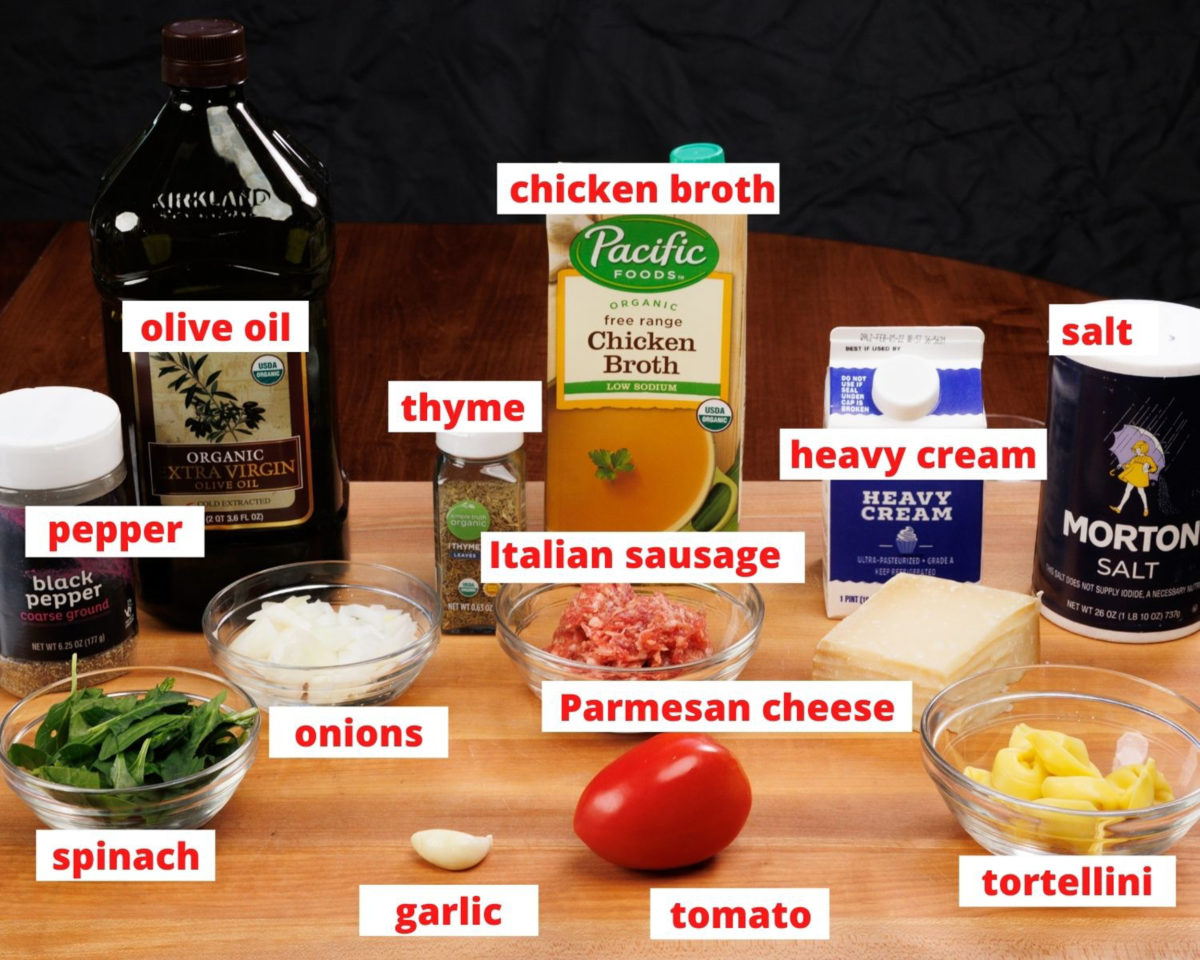 the ingredients found in tortellini soup on a wooden cutting board.