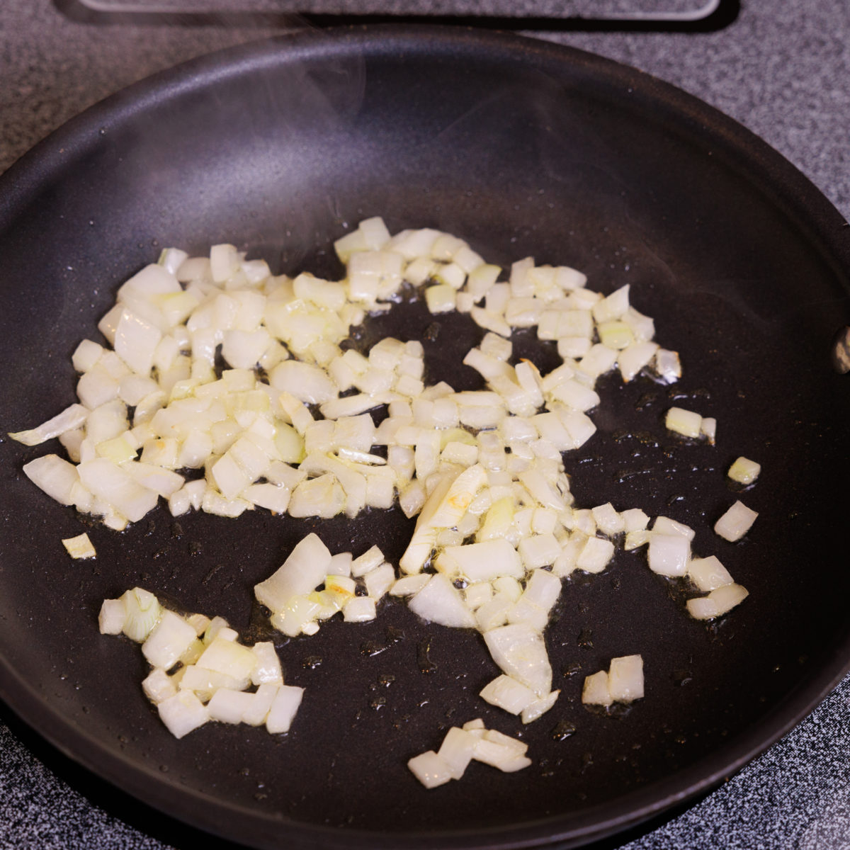 chopped onions in a black saute pan.