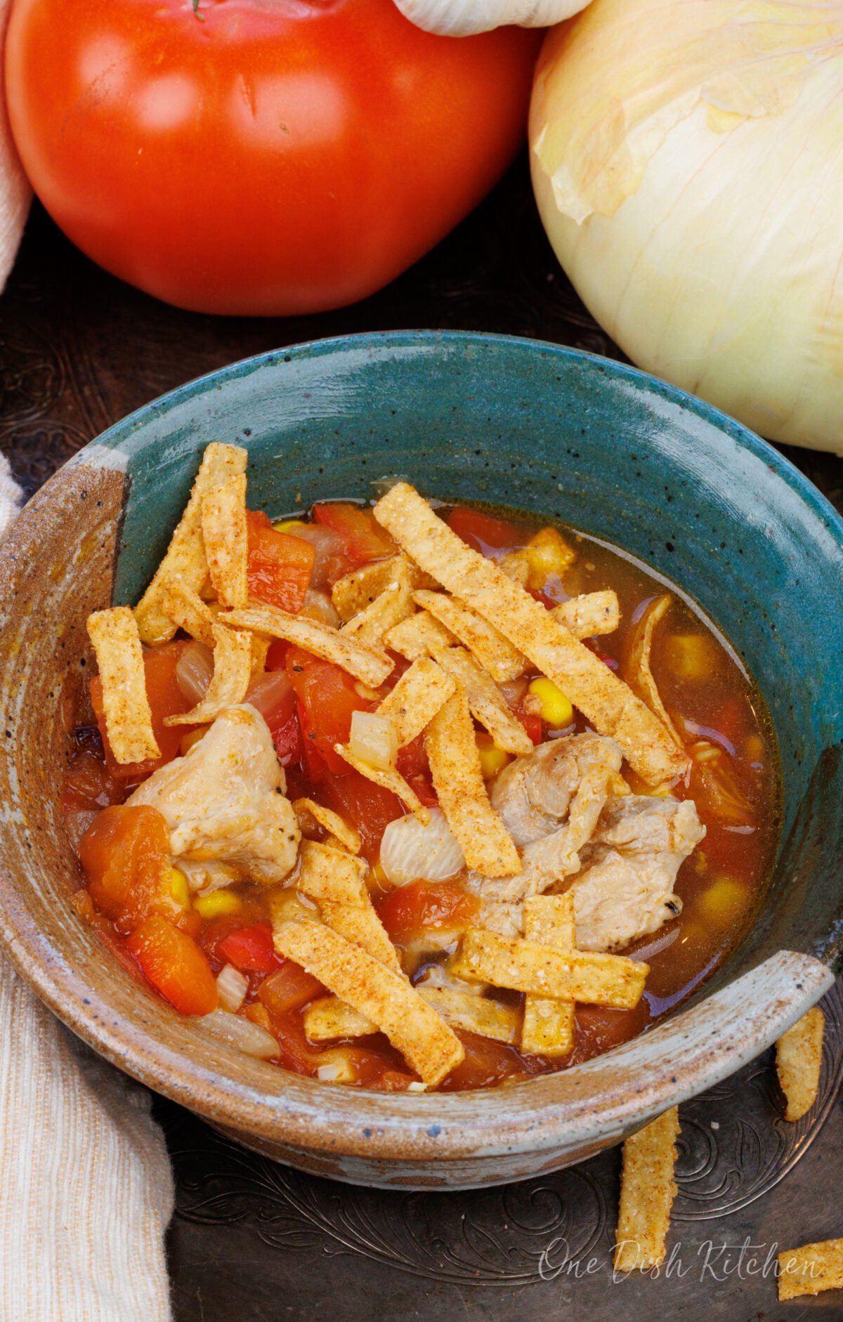 an overhead view of chicken tortilla soup with fried tortilla strips on top.