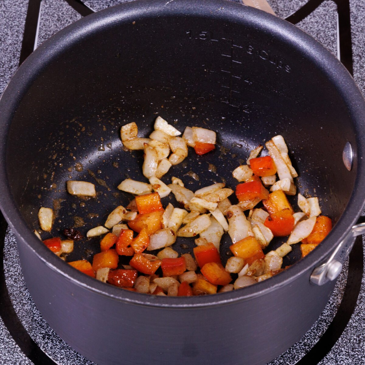 chopped onions, peppers, garlic and seasoning sauteeing in a small pot.