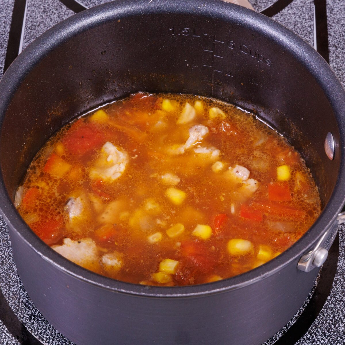chicken tortilla soup in a small black pot.