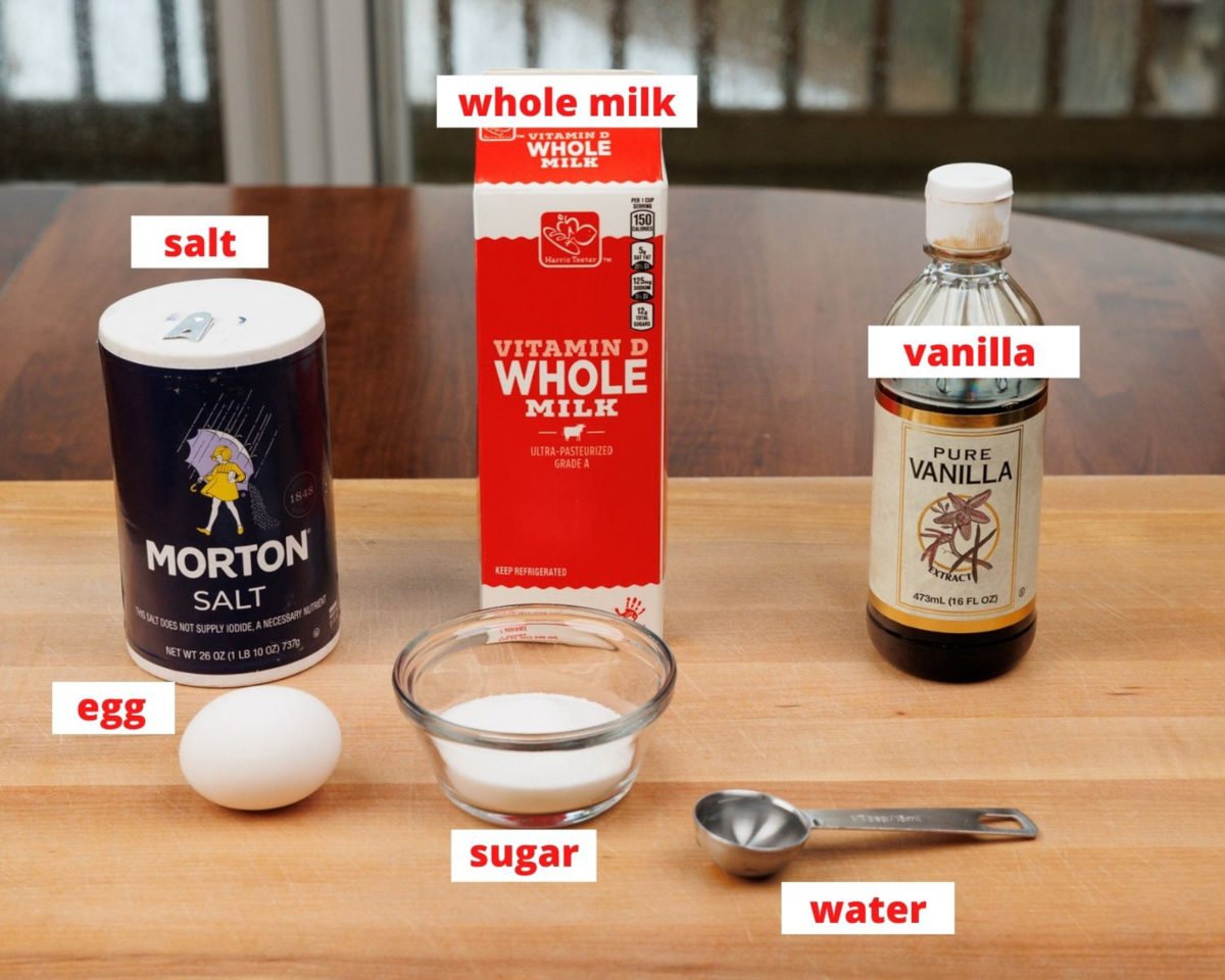 ingredients to make flan on a wooden kitchen table.