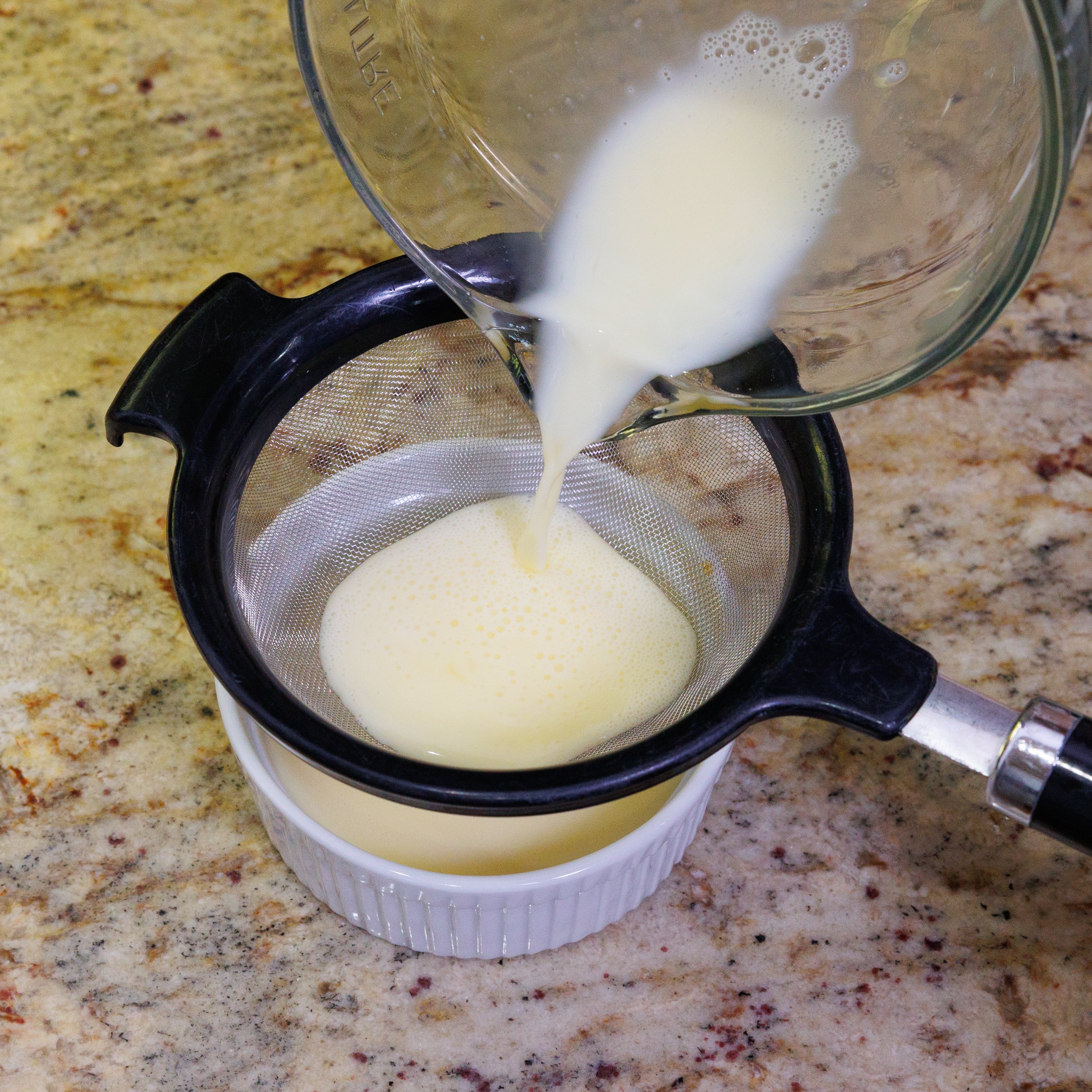 straining custard before putting it into a ramekin.