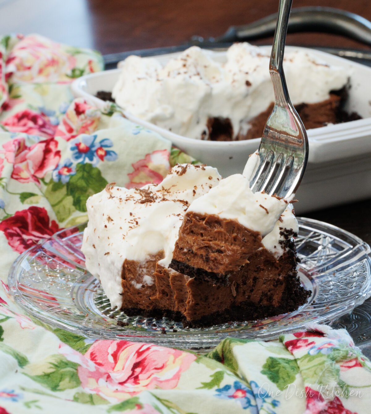 a piece of french silk pie on a fork next to the plate holding the rest of the pie.